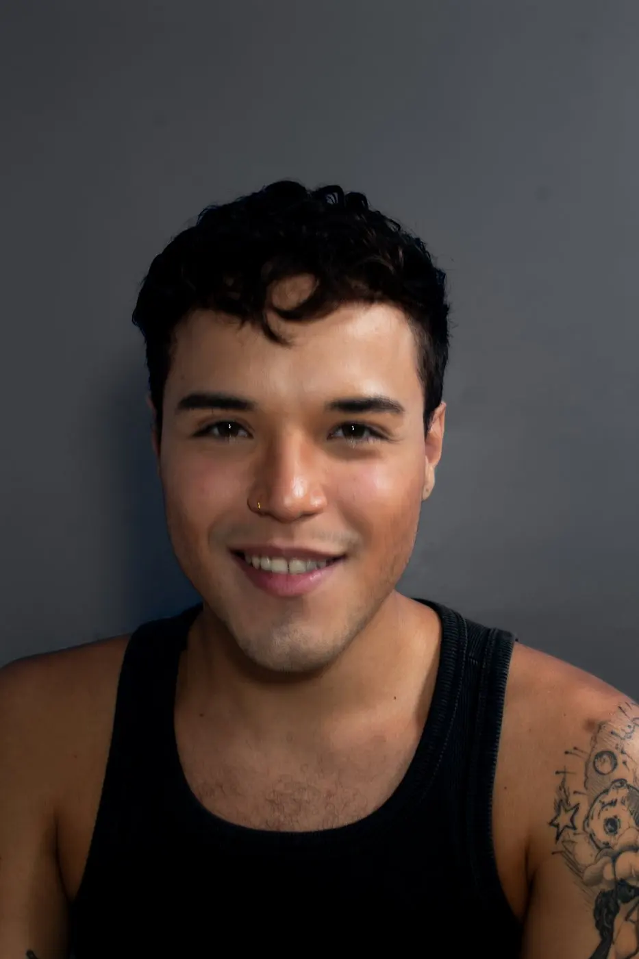 Retrato de Lucas Barreto sorrindo, em fundo cinza